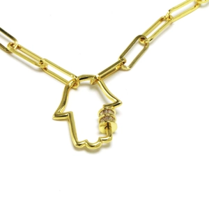 Macro shot of gold paperclip chain necklace with a crystal-studded Hamsa Hand pendant