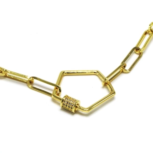 Macro view of gold paperclip chain necklace with a diamond-set geometric clasp lock