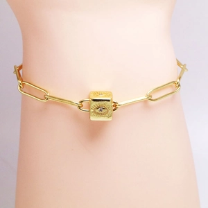 Bracciale a catena a graffetta dorata con ciondolo a cubo malocchio e zircone incastonato