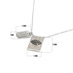 Detalle del colgante rectangular Evil Eye con etiqueta Good Luck y pavé de circonitas