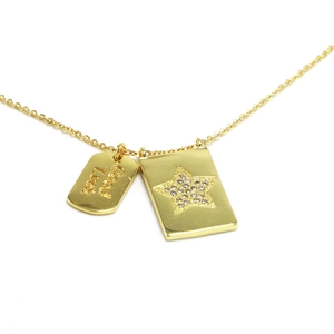 Detalle del collar chapado en oro con colgante de estrella y placa Good Luck