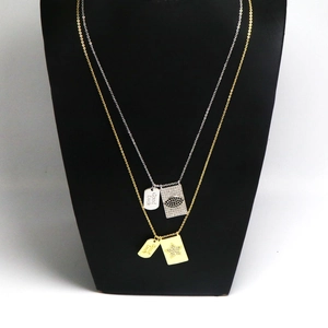 Detalle de collares dorados y plateados con colgante Good Luck y motivo de ojo de circón