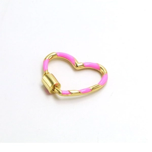 Macro view of a gold heart-shaped screw clasp with pink enamel for DIY jewelry