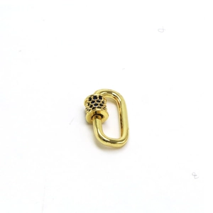 Macro detail of gold-plated heart screw clasp with blue cubic zirconia pave setting