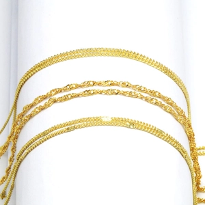 Elegantes Set aus goldbeschichteten Wasserwellen und Schlangenketten auf weißem Podest