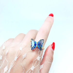 Detailaufnahme eines goldenen Schmetterlingsrings mit blauen Kristallen und Diamanten