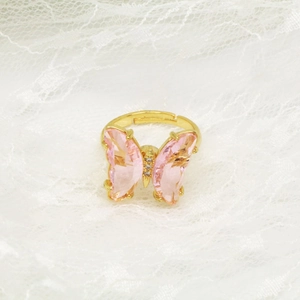 Makroaufnahme verstellbarer goldener Schmetterlingsring mit rosa Kristallen und Zirkonia