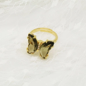 Detailansicht eines Schmetterlingsrings mit rauchgrauem Glas und verstellbarem Goldband
