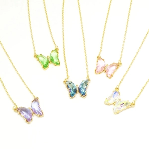 Detail of colorful crystal butterfly pendants in purple, green, blue, and pink gold chains