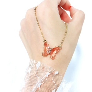 Pink translucent crystal butterfly pendant necklace on a delicate gold chain for women