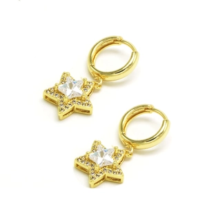 Gros plan de boucles d'oreilles étoiles dorées avec zircon central et entourage serti