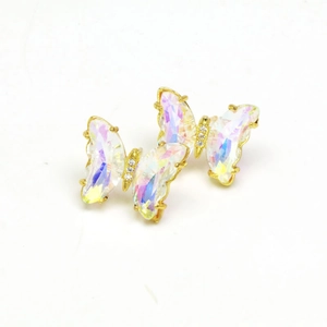Close-up of butterfly stud earrings with iridescent crystal wings and gold accents