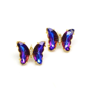 Macro detail of butterfly earrings with colorful faceted crystals and golden metal body