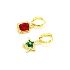 Détail de boucles d'oreilles dorées avec cristal rouge rectangle et étoile verte