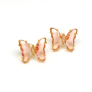Detail view of pink crystal butterfly earrings with gold metallic frame and tiny diamonds