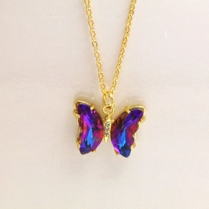 Détail du pendentif papillon en cristal dégradé violet avec une chaîne dorée