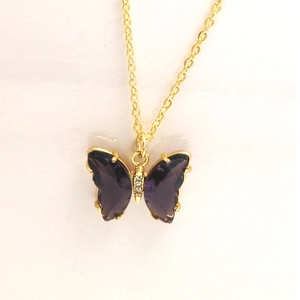 Vue détaillée du pendentif papillon en cristal violet avec chaîne dorée et zircons