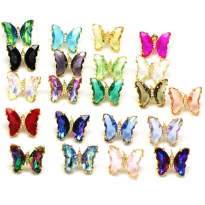 Multiple styles of crystal butterfly stud earrings with colorful faceted glass and gold plating