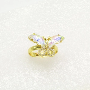Makroaufnahme von Schmetterling-Ring mit schillernden Flügeln und weißen Kristallen