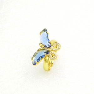 Detail eines goldenen Schmetterlingsrings mit blauen Kristallen und weißen Zirkonia