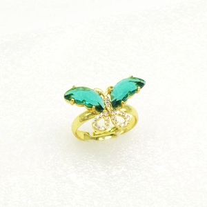 Makroaufnahme eines verstellbaren Goldrings mit grünem Schmetterling und Pavé-Steinen