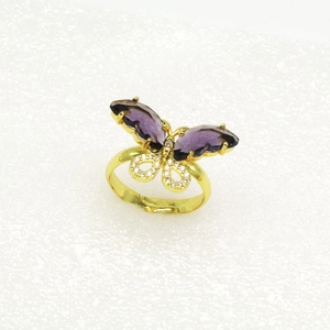Detailaufnahme eines goldenen Schmetterlingsrings mit lila Kristallen und Zirkon-Steinen