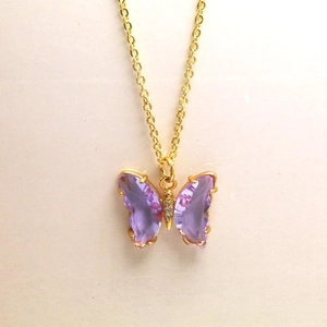 Vue détaillée du pendentif papillon en cristal violet avec placage d'or et micro diamants