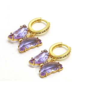 Détail de boucles d'oreilles papillon avec verre facetté violet et strass pavés