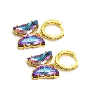 Gros plan sur les boucles d'oreilles papillon dorées avec cristal dégradé et zircon