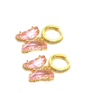 Détail de boucles d'oreilles papillon dorées avec cristal rose et micro-pavage de zircons