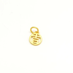 Macro shot of gold matte round pendant featuring a hollowed Chinese character Lucky