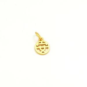 Macro shot of gold-plated pendant featuring hollowed Chinese character An for peace