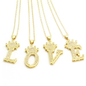 Detail view of gold-plated crown alphabet pendants L, O, V, E with zircon stones