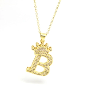 Detailed close-up of golden crown initial B necklace with zircon paved pendant