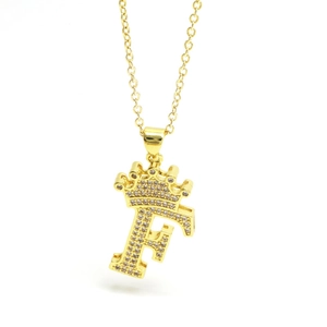 Close-up of golden letter F necklace with a small crown and pavé zircon stones