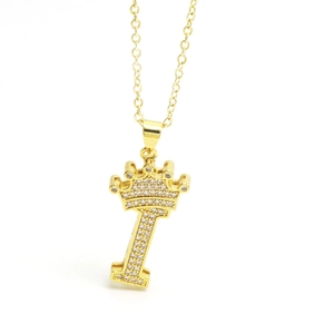 Macro shot of gold pendant featuring crown letter I encrusted with sparkling cubic zirconia