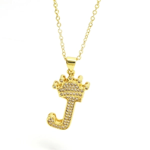 Macro view of gold crown letter J pendant with micro-paved cubic zirconia stones