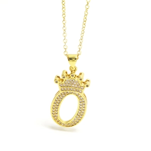 Macro detail of gold crown letter O pendant with cubic zirconia micro-pave setting