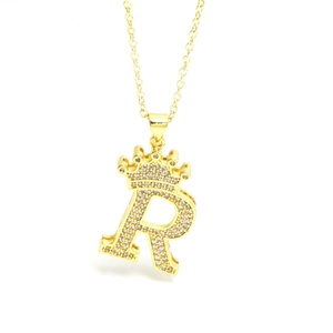 Macro shot of gold-plated crown initial R pendant with shimmering zircon pavé setting