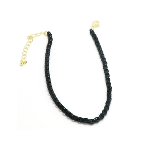 Detalle de pulsera de cuentas cuadradas negras mate con cierre de langosta dorado ajustable
