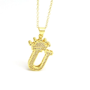 Detailed view of gold crown letter U pendant with sparkling cubic zirconia inlay