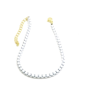 Detalle de collar de cuentas en blanco y negro con cierre de langosta dorado y cadena de extensión