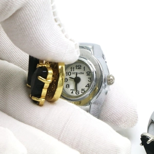 Détail macro d'une montre bague rétro avec pierre noire et cadran blanc sur l'anneau