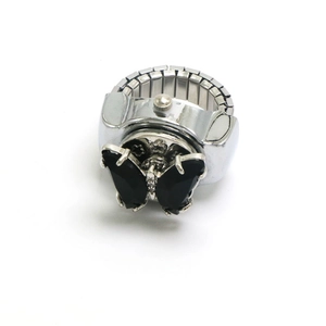 Détail de la bague montre papillon argentée avec gemmes noires et bande de métal extensible