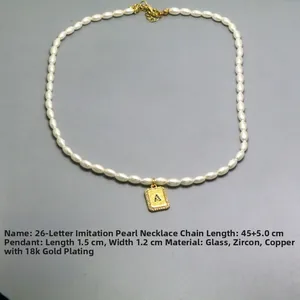 Detail showing letter A pendant with 18k gold plating on an imitation pearl necklace