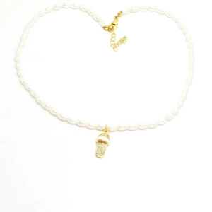 Detailopname van een parelketting met een met kristallen ingelegde slipper hanger
