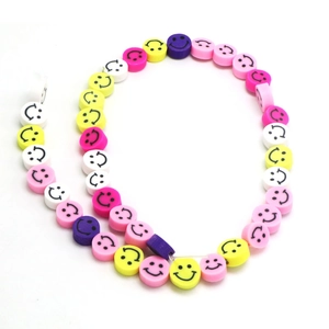 Flat lay of colorful smiley face polymer clay beads for DIY jewelry making sets