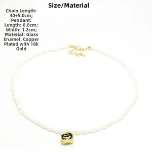 Detail van de parelketting met een zwarte Love Friends hanger van 18k verguld koper