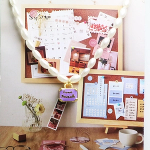 Detail van parelketting met een paarse kofferhanger en gravure Love Travels op tafel