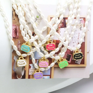 Vintage parelketting met diverse kleurrijke Love Travels kofferhangers in set